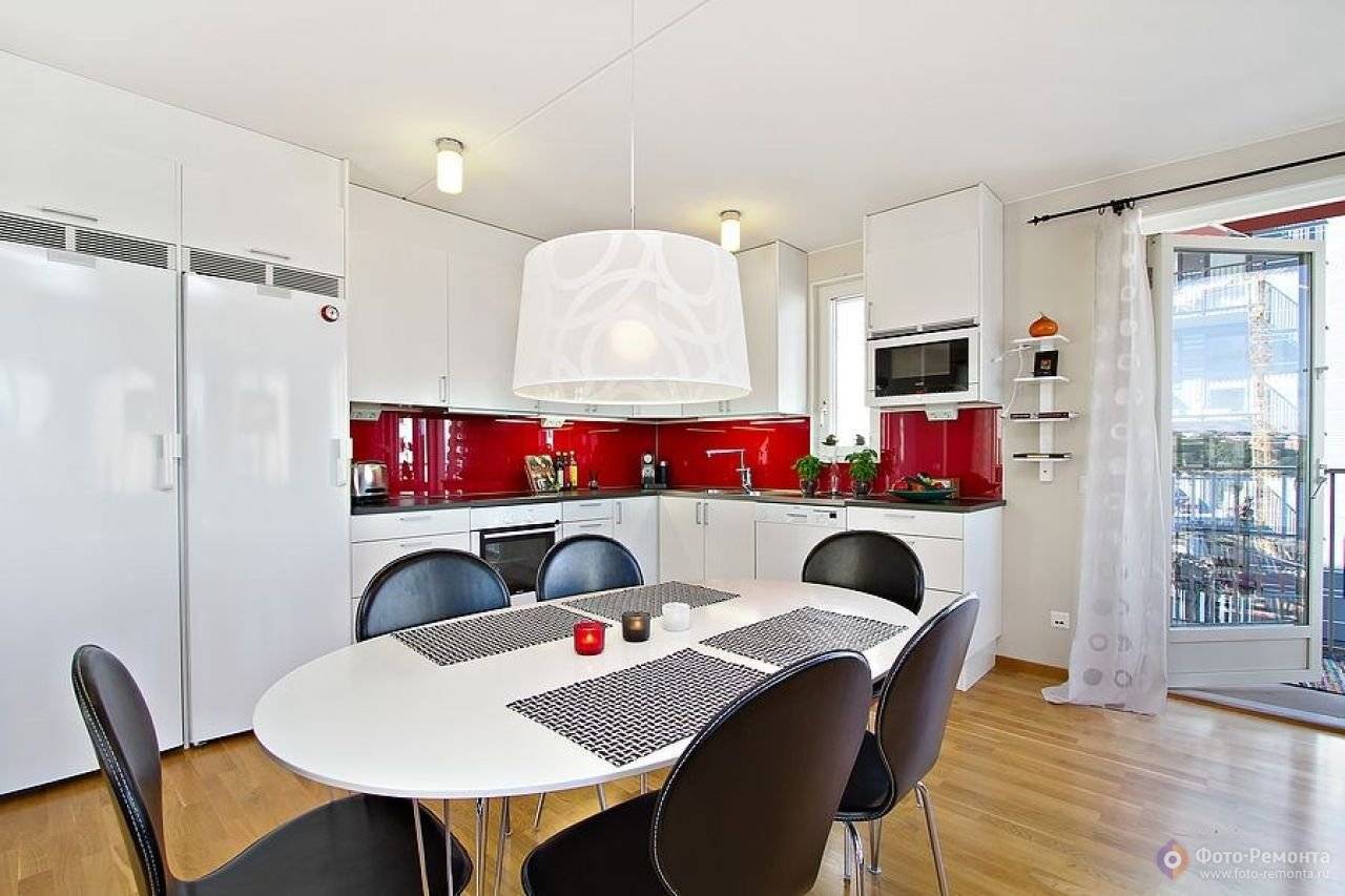 Кухня с ярким цветовым акцентом, в качестве которого выступает красный фартук. За счет встроенной техники визуальный шум минимальный. 